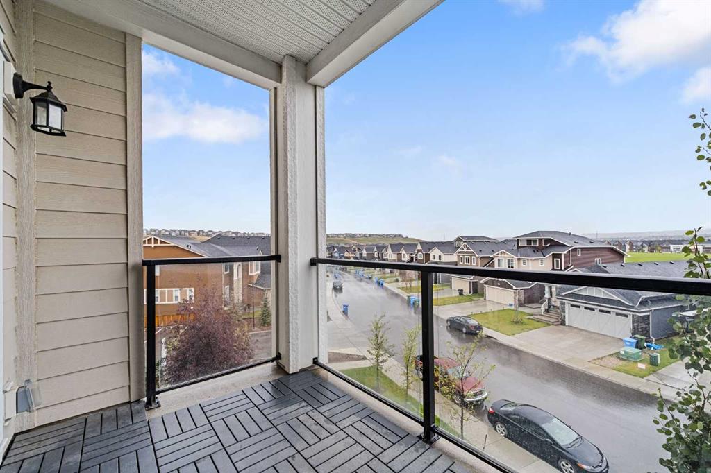 Private balcony with glass railing and neighbourhood views in Sage Meadows Park Calgary condo