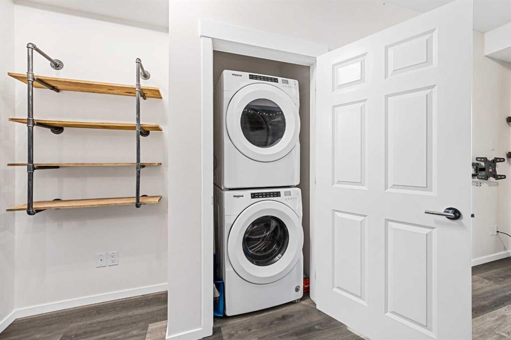 In-suite stacked washer and dryer with storage closet near kitchen and living room.